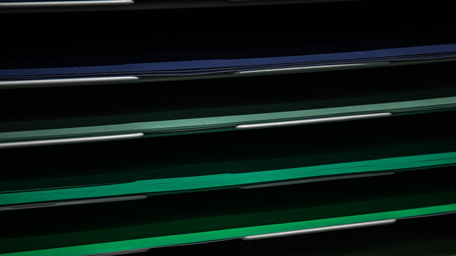Close-up view of assorted colored paper in a stacking rack, perfect for school or office use.