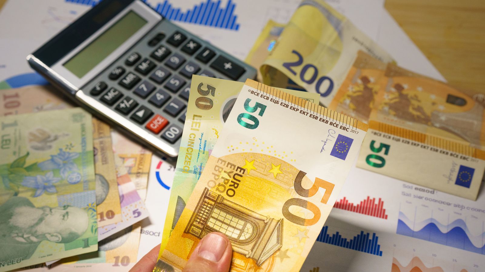 Euro and Romanian Lei currency with calculator on a financial desk setup.