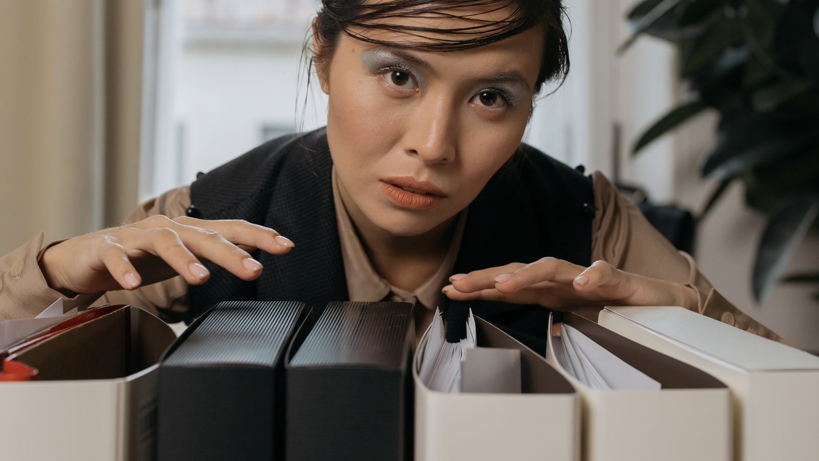 Woman organizing file folders in an office, showcasing focus and efficiency. Perfect for business and workplace themes.