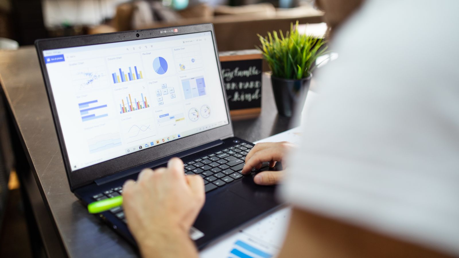 Focused business analysis with charts and graphs on a laptop in a modern office setting.
